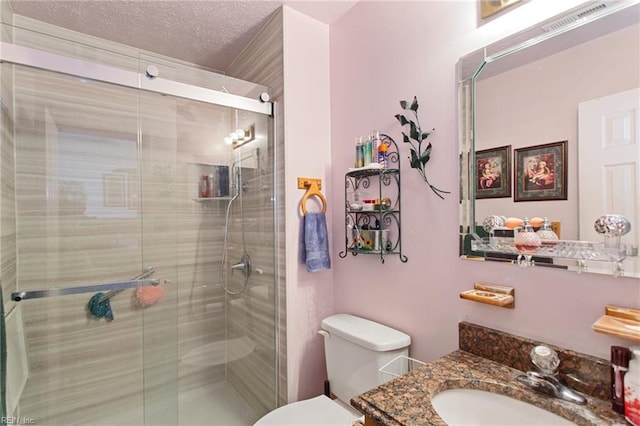 bathroom featuring toilet, an enclosed shower, a textured ceiling, and vanity