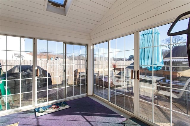 sunroom / solarium featuring vaulted ceiling with skylight