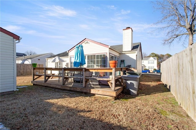 back of property with a yard and a wooden deck