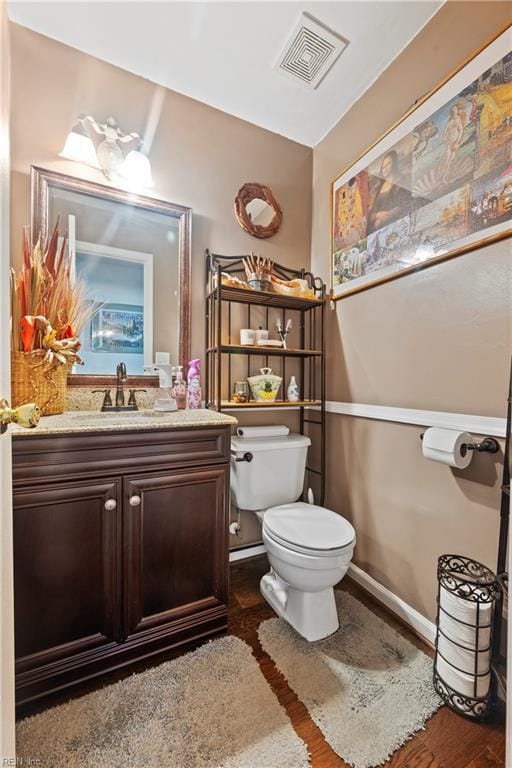 bathroom with toilet, wood-type flooring, and vanity