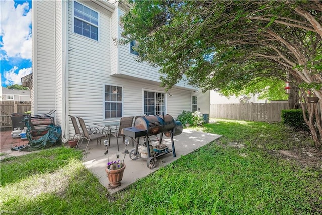 rear view of house featuring a lawn and a patio area