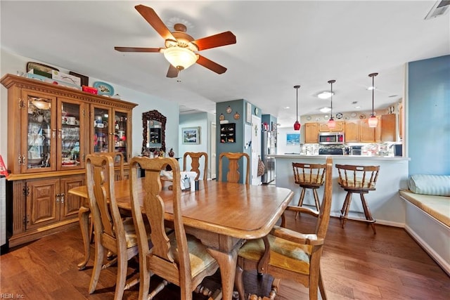 dining area with ceiling fan and dark hardwood / wood-style floors