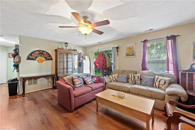 living room featuring ceiling fan and dark hardwood / wood-style floors