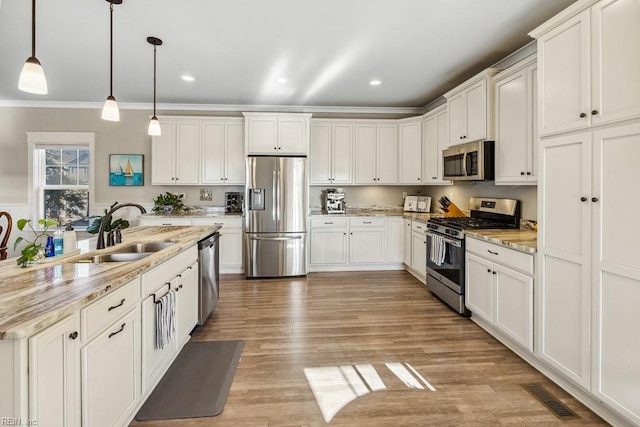 kitchen featuring sink, white cabinets, pendant lighting, and appliances with stainless steel finishes