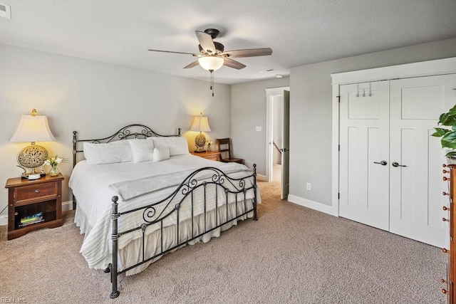 bedroom featuring ceiling fan, a closet, and light carpet