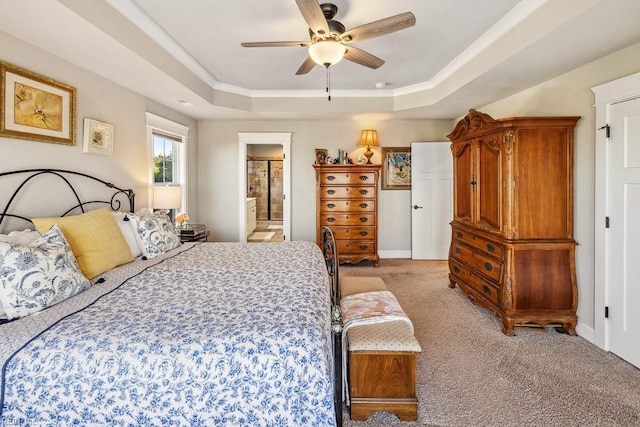 carpeted bedroom featuring ornamental molding, ceiling fan, a tray ceiling, and connected bathroom