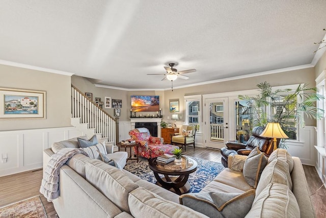 living room with wood-type flooring, ceiling fan, french doors, and crown molding