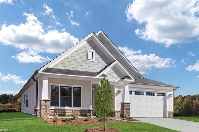 craftsman inspired home featuring a garage and a front lawn