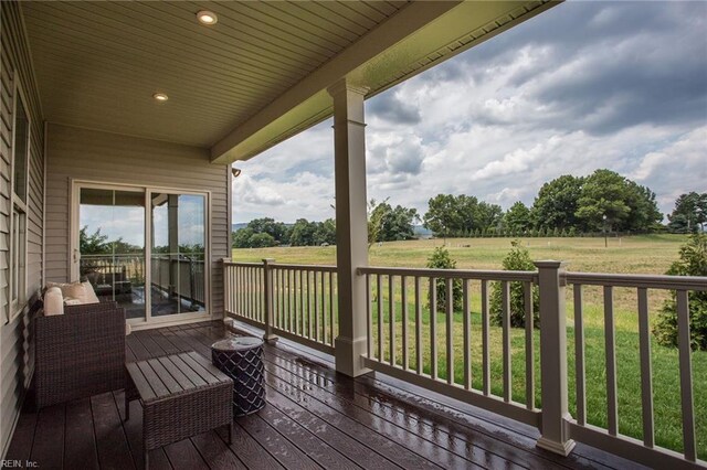 wooden deck with a porch and a rural view