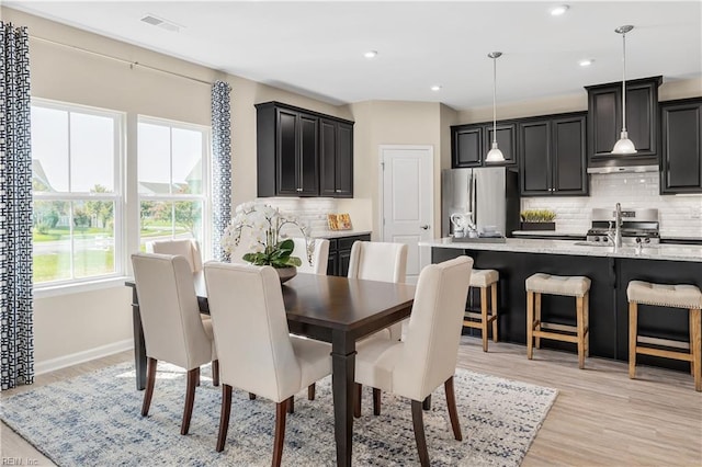 dining space with sink and light hardwood / wood-style flooring