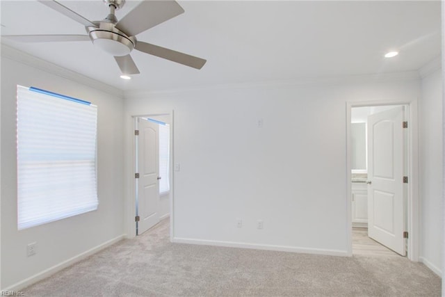 spare room featuring ceiling fan, light colored carpet, and crown molding