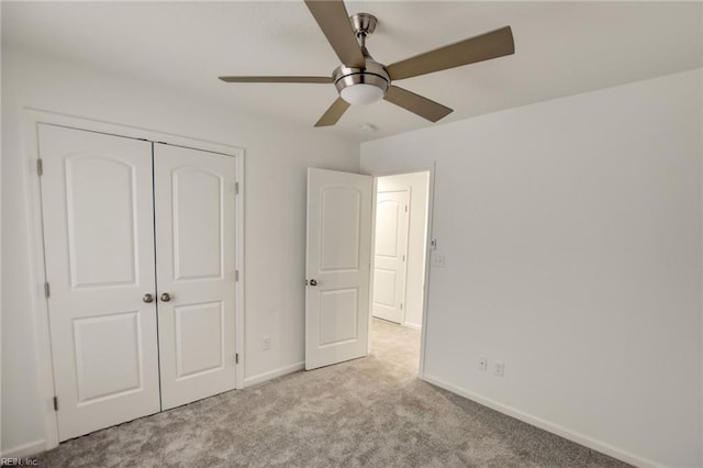 unfurnished bedroom featuring ceiling fan, light colored carpet, and a closet