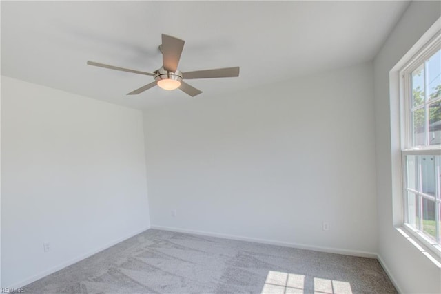 carpeted spare room featuring ceiling fan and a healthy amount of sunlight