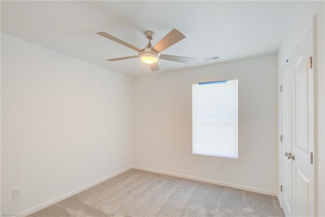 unfurnished room featuring ceiling fan and light carpet