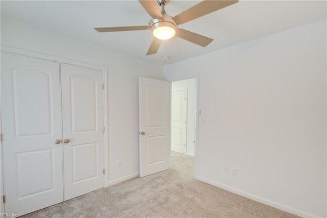 unfurnished bedroom with ceiling fan, a closet, and light colored carpet