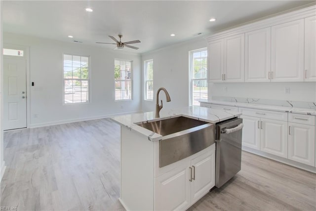 kitchen with light hardwood / wood-style floors, white cabinets, dishwasher, and an island with sink