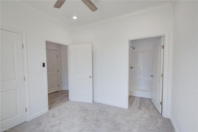 unfurnished bedroom featuring ceiling fan, crown molding, ensuite bathroom, and light carpet