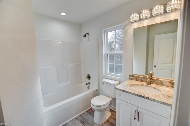 full bathroom with tub / shower combination, vanity, wood-type flooring, and toilet