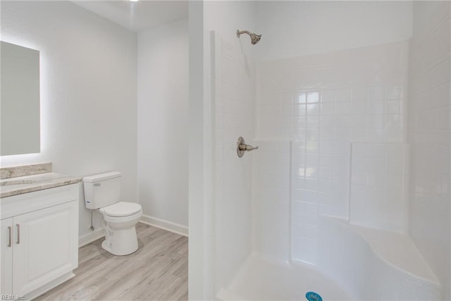 bathroom with toilet, a shower, hardwood / wood-style floors, and vanity