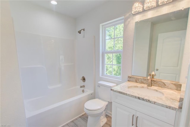 full bathroom featuring wood-type flooring, toilet, vanity, and bathing tub / shower combination