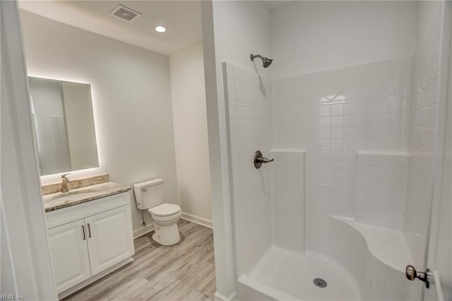 bathroom featuring toilet, walk in shower, hardwood / wood-style floors, and vanity