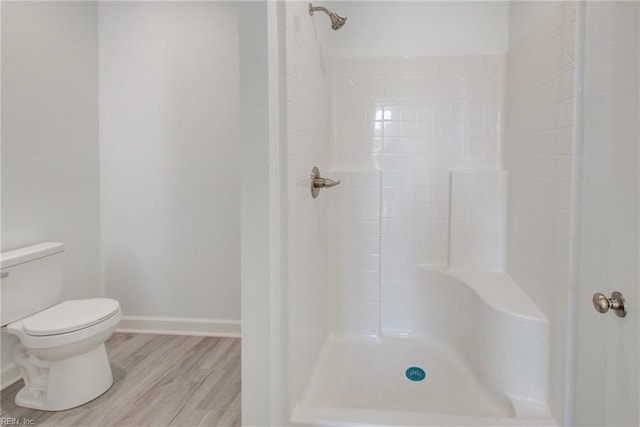 bathroom featuring toilet, walk in shower, and hardwood / wood-style flooring