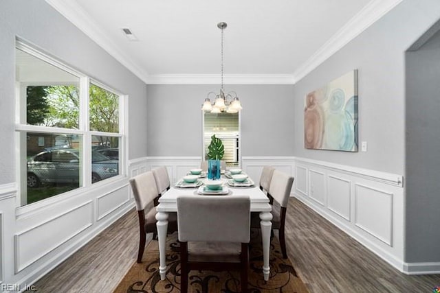 dining room featuring an inviting chandelier, ornamental molding, and dark wood-type flooring