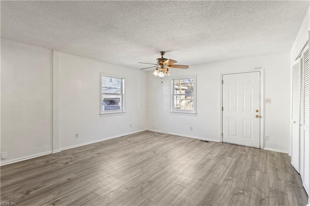 spare room featuring wood-type flooring, a textured ceiling, and ceiling fan