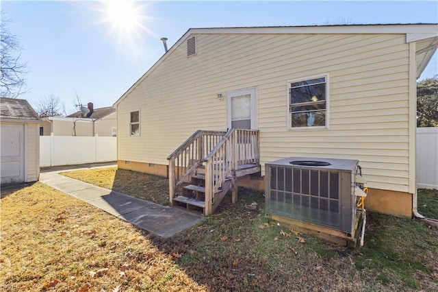 rear view of property with a storage unit and central AC unit