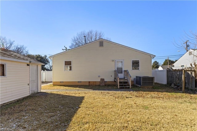 rear view of house with a yard and cooling unit