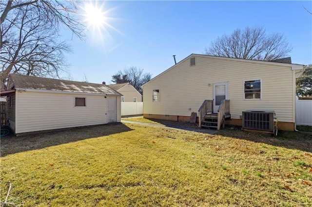 rear view of house featuring central AC and a yard