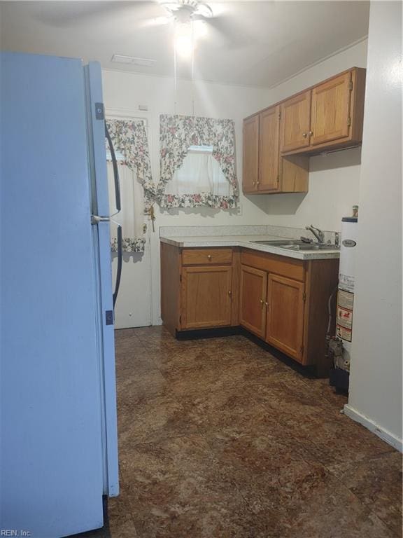 kitchen with sink, water heater, and white fridge