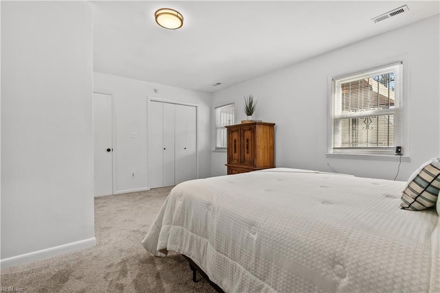 bedroom with a closet and light carpet