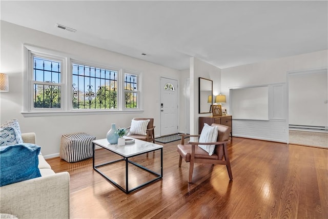 sitting room featuring baseboard heating and hardwood / wood-style flooring