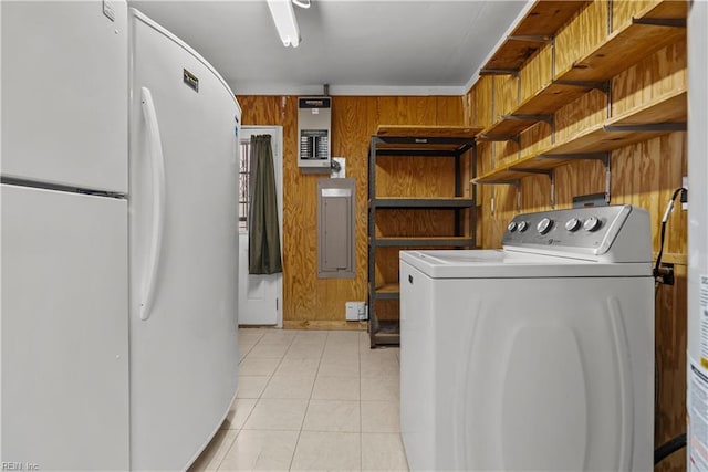 laundry area featuring washer / dryer, wood walls, light tile patterned floors, and electric panel