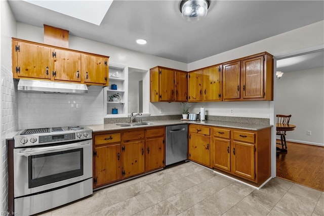 kitchen with stainless steel appliances, a skylight, decorative backsplash, and sink