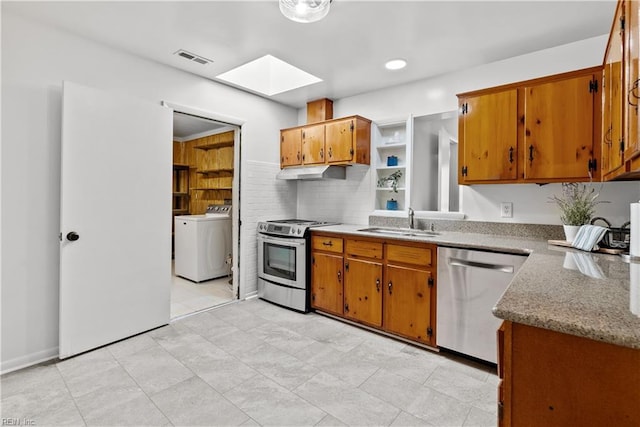 kitchen featuring decorative backsplash, a skylight, washer / clothes dryer, appliances with stainless steel finishes, and sink