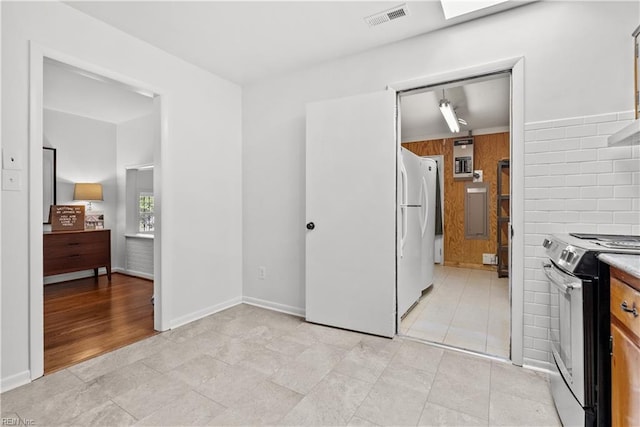 interior space with light tile patterned floors, electric range, and white fridge