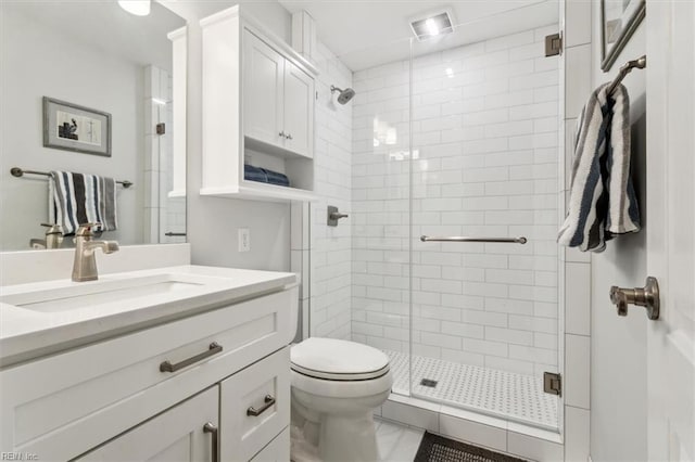 bathroom featuring toilet, vanity, and a shower with shower door