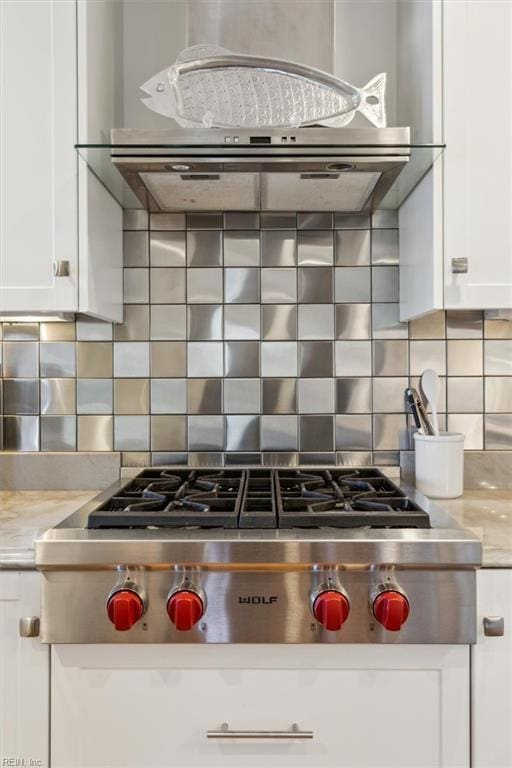 kitchen featuring white cabinets, stainless steel gas cooktop, tasteful backsplash, and wall chimney exhaust hood