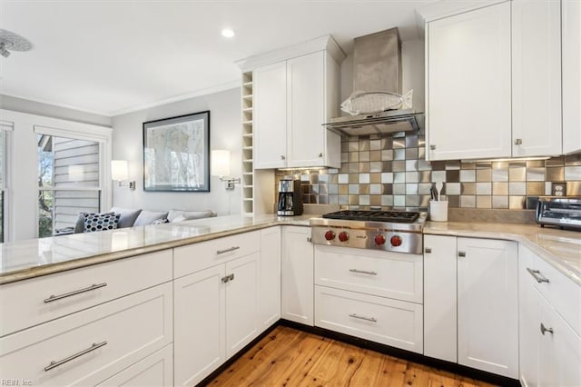 kitchen featuring white cabinetry, backsplash, and wall chimney exhaust hood