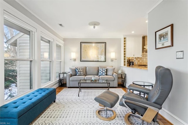 living room featuring ornamental molding and light hardwood / wood-style flooring