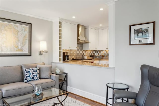 living room featuring crown molding and light hardwood / wood-style flooring