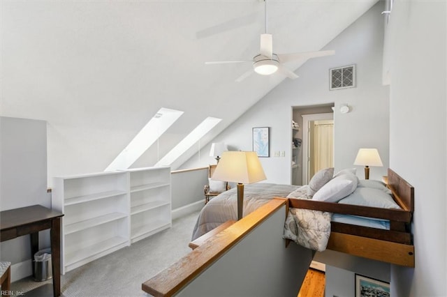 carpeted bedroom with ceiling fan and lofted ceiling with skylight