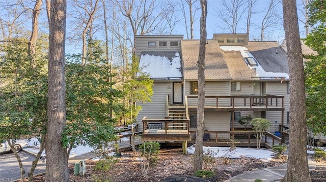 back of house featuring a balcony and a wooden deck