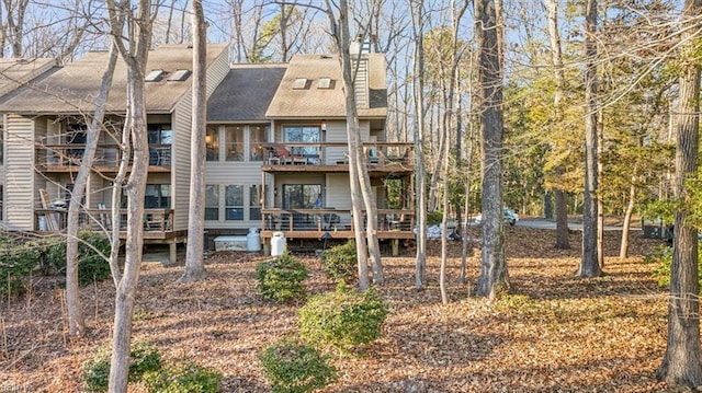 rear view of property featuring a wooden deck