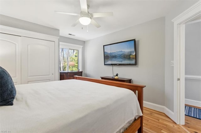 bedroom featuring ceiling fan, light hardwood / wood-style floors, and a closet