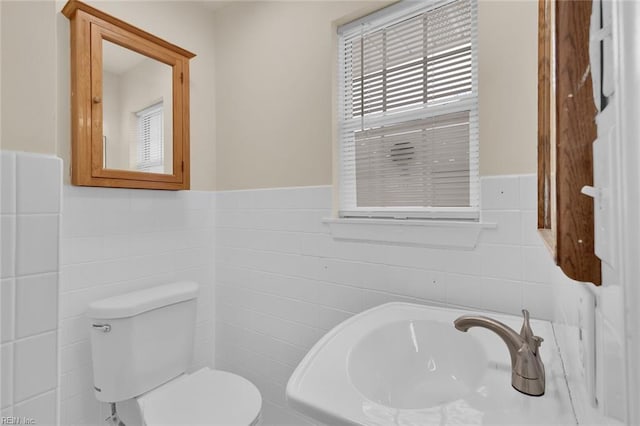 bathroom featuring tile walls, sink, and toilet