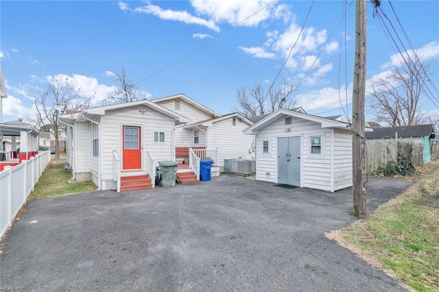 back of house with central AC and a shed