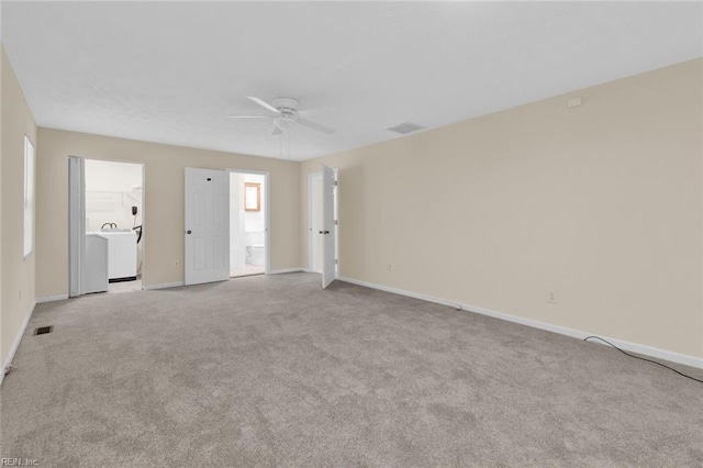 carpeted empty room with washer / dryer and ceiling fan